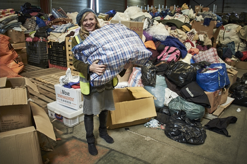 Refugee charity worker sorting out clothing donations in Calais.
