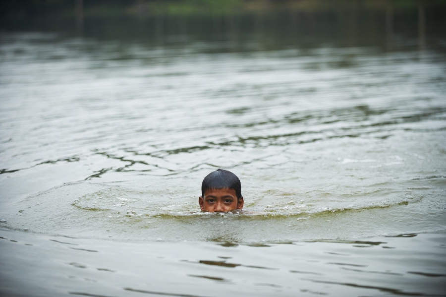 Boy swimming in river, Cambodia.