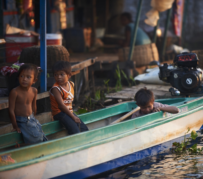 Children sitting in a boat in a floating village in Siem Reap.
