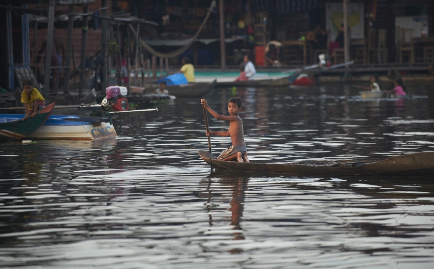 Child rowing boat in floating village in Siem Reap.