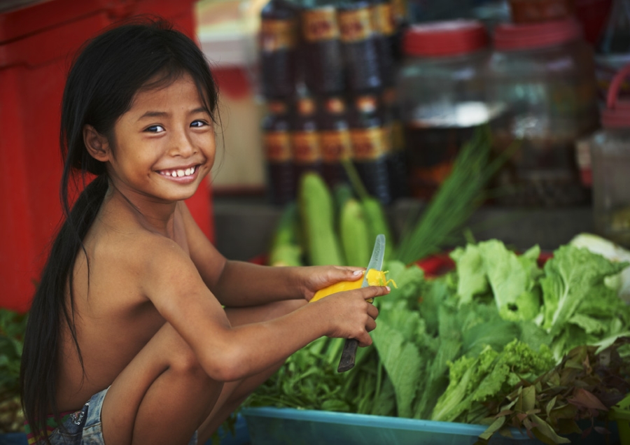 Girl peeling vegetable in Cambodia.