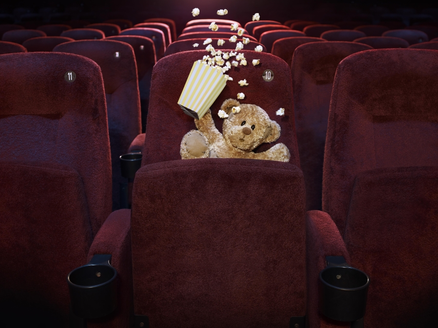 Teddy in cinema falling down chair.