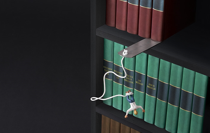 Minifigure performing bungee jump from bookshelf