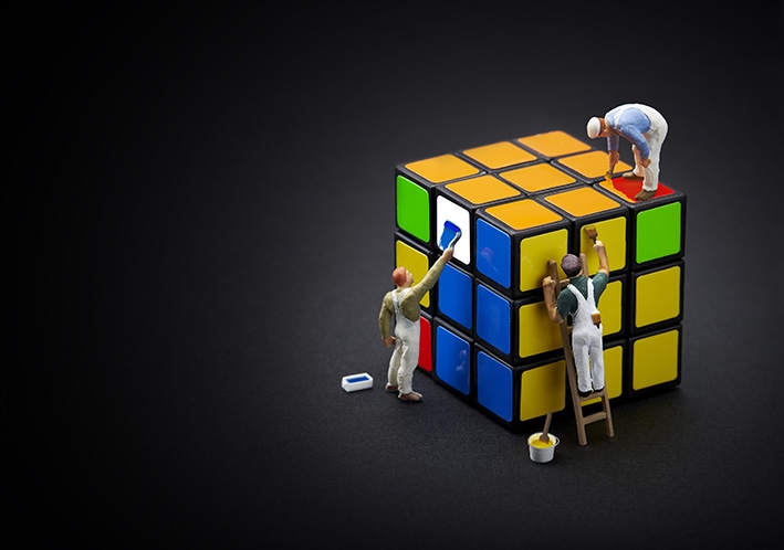 Minifigures painting a Rubik's cube.