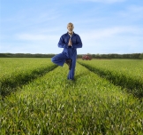 Farmer doing yoga pose in field.