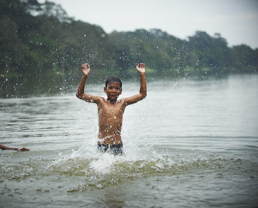 Boy walking out of river in Cambodia.