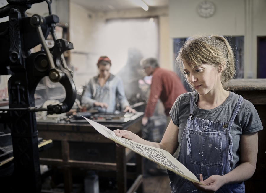 Female letterpress employee appreciating a print.