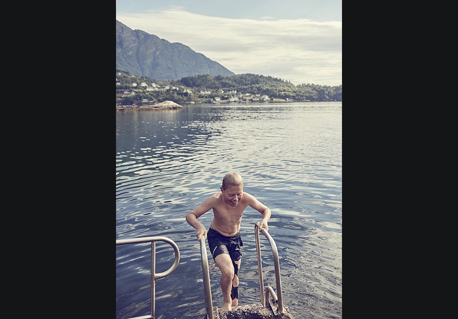 Young Male climbing out of Norwegian Lake