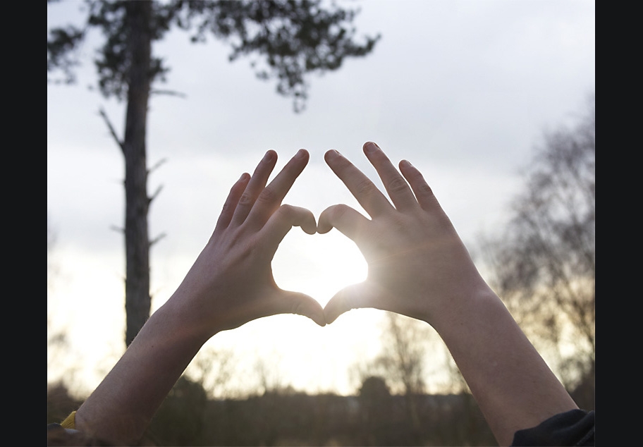 Female forming hands in the shape of a heart